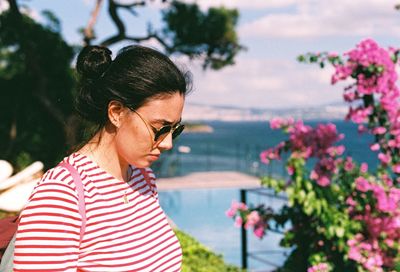 Woman wearing sunglasses standing against plants