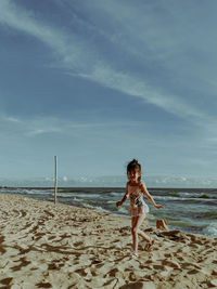 Portrait of woman on beach against sky