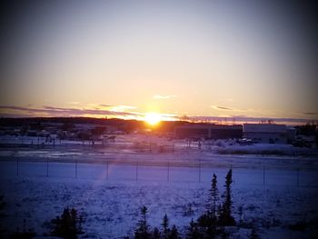 Scenic view of frozen lake against clear sky during sunset