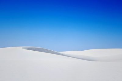 Scenic view of snowcapped mountains against clear blue sky