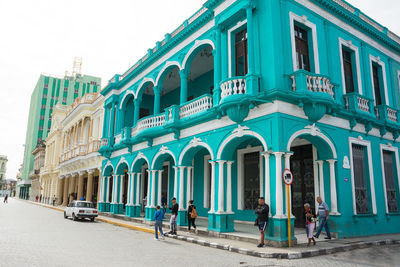 People walking on street against buildings in city