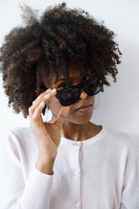 Beautiful black woman with afro hair wearing futuristic video recording glasses