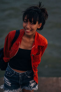 Portrait of smiling young woman standing outdoors