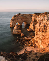 Rock formations by sea against sky