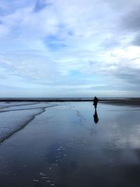 Man standing on beach against sky