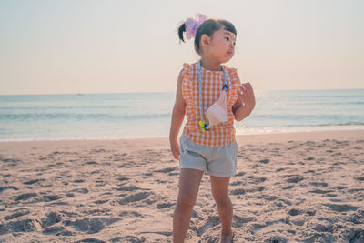 Full length of boy looking at beach against sky