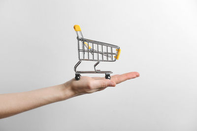 Close-up of hand holding umbrella against white background