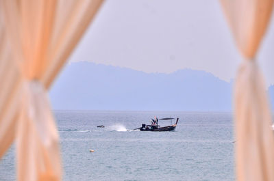 Boat sailing on sea against sky