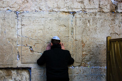 Woman standing against brick wall