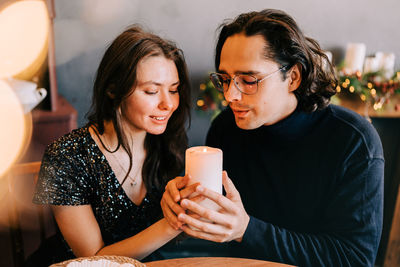 Young man and woman romantic couple couple hug at the dinner room christmas