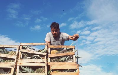 Low angle view of man standing against blue sky