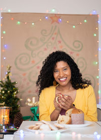 Portrait of a smiling woman sitting on table