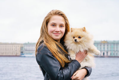 Lifestyle image of happy attractive young woman in black leather jacket walking