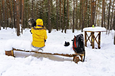 Rear view of people on snow covered field