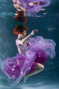 Woman with eyes closed swimming in pool