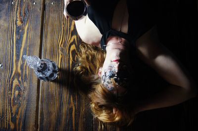 Directly above shot of woman wearing mask lying down on table