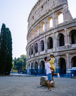 Woman in front of historical building against sky