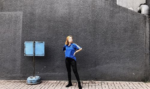 Portrait of woman standing against wall