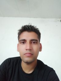 Portrait of young man against wall