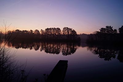 Reflection of trees in lake during sunset