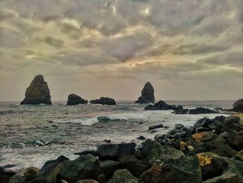 Rocks on beach against sky