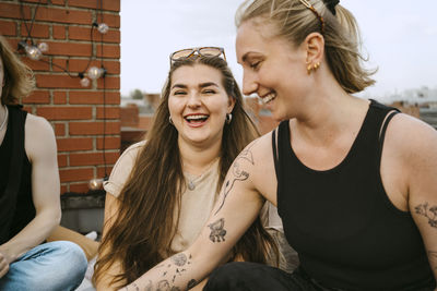 Cheerful female friends enjoying on rooftop