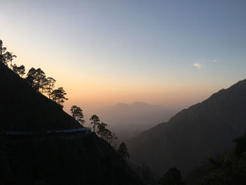 Scenic view of silhouette mountains against sky during sunset