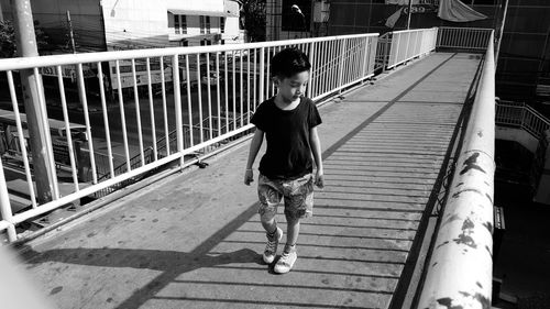High angle view of boy walking on bridge