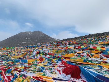 Low angle view of multi colored flags against cloudy sky