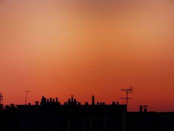 Silhouette buildings against orange sky