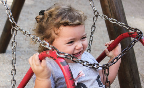 Close-up of cheerful girl on swing