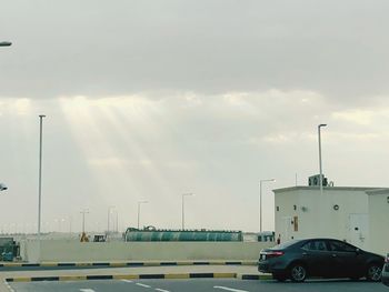 Cars on road in city against sky