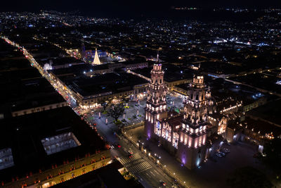 High angle view of illuminated city buildings at night