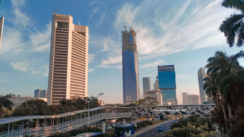 View of modern buildings against cloudy sky