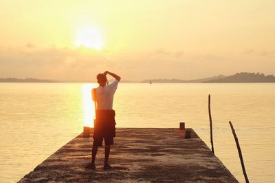 Woman standing on beach at sunset