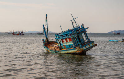 Fishing boats in sea against sky