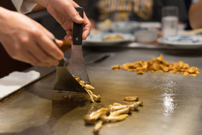 Cropped hands of man preparing food in kitchen