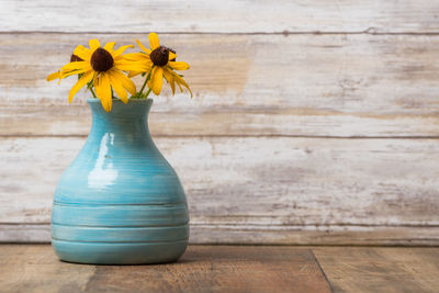 Close-up of yellow flower vase on table