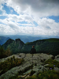 Rear view of man looking at mountain against sky