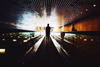 Silhouette person standing on walkway at airport