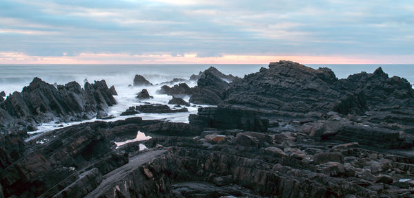 Scenic view of sea and mountains against sky