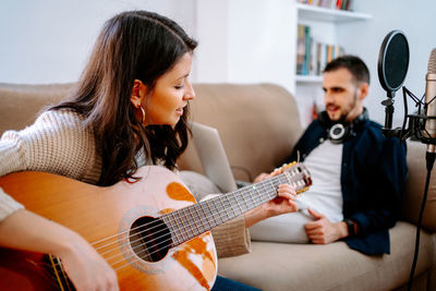 Girl playing guitar on sofa