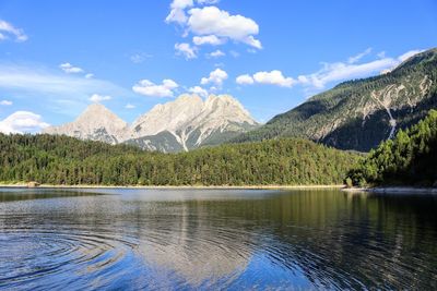 Scenic view of lake and mountains against blue sky