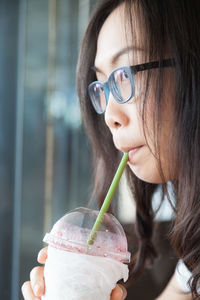 Close-up of woman drinking juice in restaurant