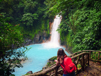 Young woman admires a waterfall.