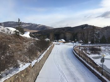 Road amidst snowcapped mountains against sky