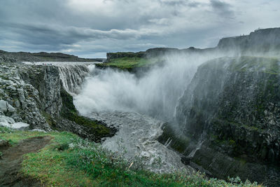 Scenic view of waterfall against sky