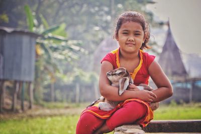 Portrait of cute girl sitting outdoors