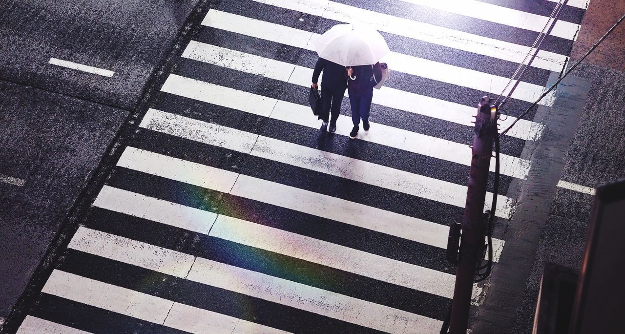 SHADOW OF MAN WALKING ON ROAD