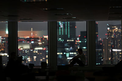 People sitting in illuminated building at night